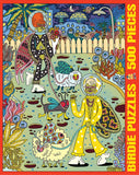A 500-piece jigsaw puzzle box cover featuring a colorful, surreal cartoon garden scene with two stylized bird characters, flowers, and a picket fence. The left side reads 'BIRDIE PUZZLES' and the right side reads '500 PIECES' in yellow text on a red background.